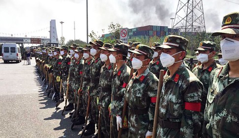 Armed police don protective masks as they prepare to tackle the blaze. Photo: PLA Daily
