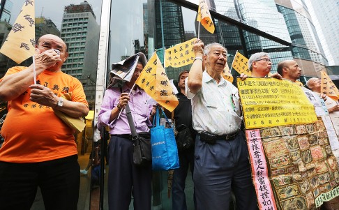 Around 20 members of the Hong Kong Reparation Association display wartime banknotes during a protest outside the Japanese consulate in Central yesterday. Photo: Sam Tsang
