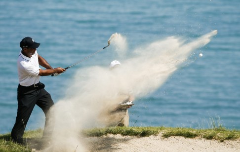 Tiger Woods hits out of a sand trap by the fourth green during round two. Photo: EPA