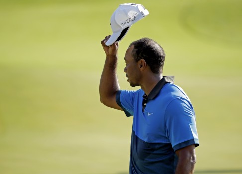 Tiger Woods tips his hat to the crowd on the 18th hole at the end of his second round. Photo: AP