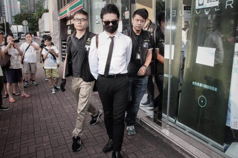Uber staff are led away by Hong Kong police following a raid on the company's offices in the city. Photo: AFP