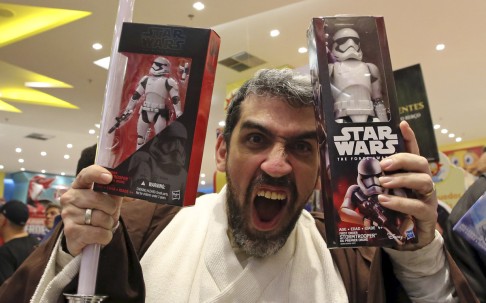 A man dressed as Obi-Wan Kenobi reacts as he buy new toys from the upcoming film 'Star Wars: The Force Awakens' on 'Force Friday' in Sao Paulo, Brazil. Photo: Reuters