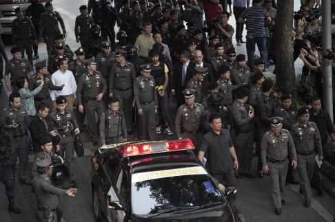 Yusufu Mieraili (centre, in yellow), takes part in a reenactment of the bombing with police officers in Bangkok. Photo: AFP