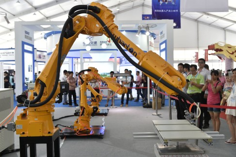 Visitors watch an industrial robot operating at the China International Internet Plus Exposition in Foshan, Guangdong Province on Thursday. Photo: Xinhua