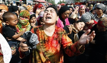 A Uyghur woman faints during a protest while other women weep in the streets of Urumqi, China, after riots in 2009. Photo: EPA