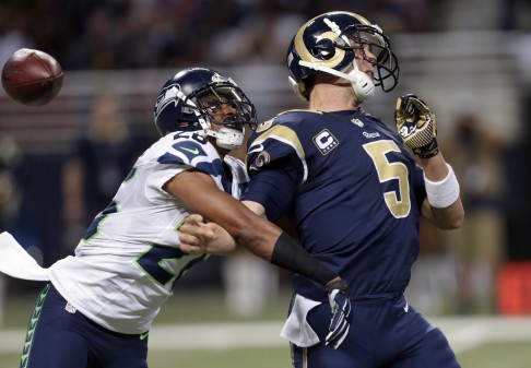 St. Louis Rams quarterback Nick Foles, right, fumbles as he is hit by Seattle Seahawks defensive back Cary Williams. Williams recovered the fumble and returned the ball for a touchdown. Photo: AP