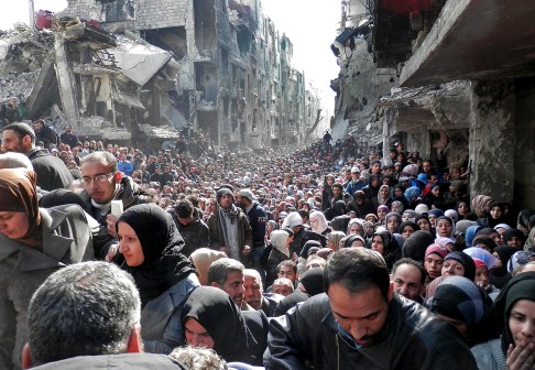 The United Nations Relief and Works Agency for Palestine Refugees (UNRWA) released this photo from January 2014, showing residents of the besieged Palestinian camp of Yarmouk, queuing to receive food supplies, in Damascus, Syria. Photo: AP