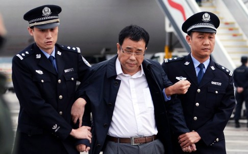 Chinese police escort Li Huabo (centre) after being repatriated from Singapore, upon his arrival at the Beijing Capital International Airport in May. Photo: Xinhua