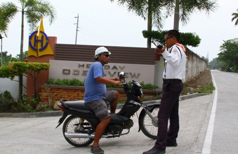 A private security guard talks to a motorist outside an entrance to the Holiday Ocean View resort in Samal island. Photo: AP