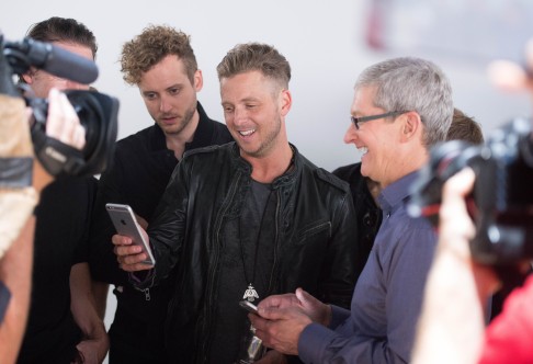 Ryan Tedder of OneRepublic (centre) views an iPhone 6s alongside Tim Cook. New features include 3D Touch, which makes it easier to deal with emails among other time-saving improvements. Photo: AFP