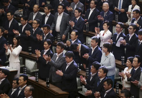 Japanese lawmakers who supported legislation loosening post-war constraints on the military applauding after the legislation was passed in the upper house. Photo: AP