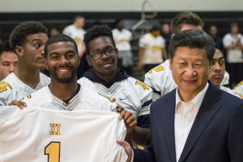 President Xi Jinping receives a football jersey bearing his name as he visits Lincoln High School in Tacoma, Washington. Photo: Reuters