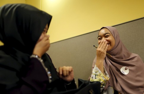 Izzaty, 26, with her chaperone, Fateha, share a laugh during the speed-dating event.