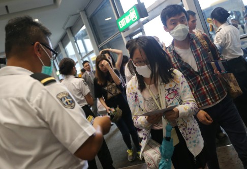 Travellers arriving in Hong Kong from Busan, South Korea, have their temperatures checked amid the outbreak of the deadly Mers virus in Korea.