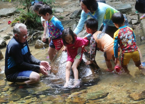 Danie Strydom (far left) leads a class in a stream; crickets are all part of the fun for Edwin Cheung. Photo: David Wong