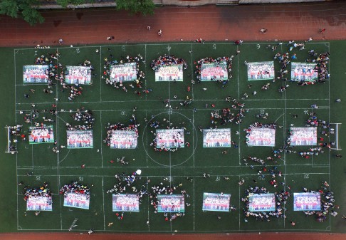 High school graduates put together giant jigsaw puzzles made from their graduation photos on the playground after sitting the 2015 national college entrance examination, or the ''Gaokao''. Photo: AFP