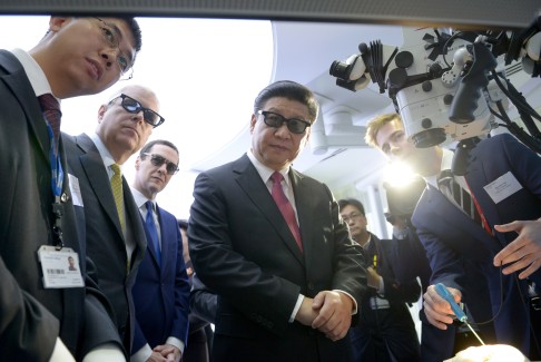 China's President Xi Jinping, centre, wear 3D glasses to view robotic equipment alongside Britain's Prince Andrew, the Duke of York, second left and Britain's Chancellor George Osborne in London. Photo: AP