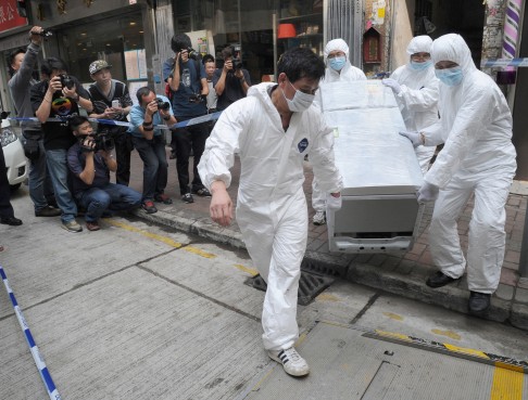 Police take away evidence from a building in Tai Kok Tsui where an elderly couple were decaptitated and their bodies chopped up. One of their sons and another man were later convicted in connection with the killings.