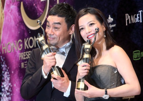 Zhao Wei holds the Best Actress award with Sean Lau who won the Best Actor award at the 34th Hong Kong Film Awards presentation ceremony.