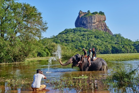 Tourists on an elephant in front of the Sigiriya fortress in Sri Lanka, a country with a rich and sometimes painful history. Photo: Corbis