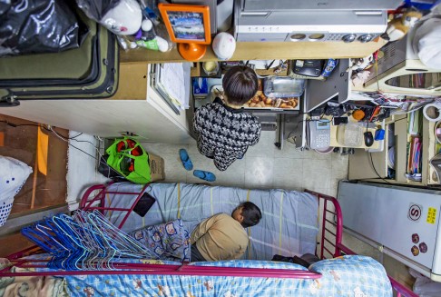 A woman and her son are seen in their 60-square-foot sub-divided flat, with a monthly rent of HK$3,800 (US$487), in Hong Kong. Photo: Reuters