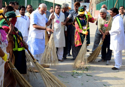 Modi handles a broom at the launch of his flagship initiative, Swachh Bharat. Photo: AFP