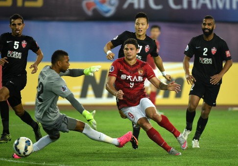 Elkeson takes a shot at goal as Al Ahli players descend on him. Photo: Xinhua