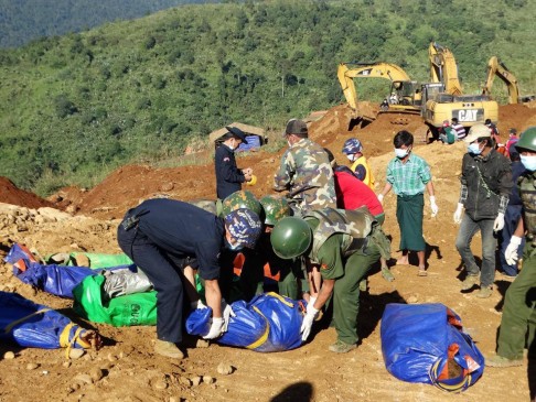 Myanmar soldiers and rescuers carry the bodies of miners in Hpakant, Myanmar's northernmost Kachin state. At least 94 bodies have been recovered on Sunday. Photo: Xinhua