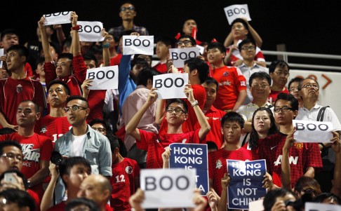 Hong Kong fans hold up signs that read "Boo" while the national anthem was being played during a world cup qualifier. Photo: AFP