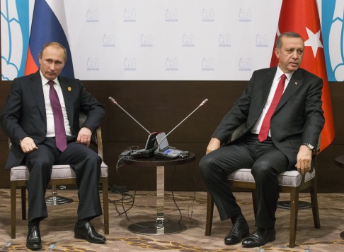 In this file photo from the G-20 summit on Nov. 16 in Antalya, Russian President Vladimir Putin (left) and Turkish President Recep Tayyip Erdogan greet the media before summit talks. Yesterday, Putin ordered the deployment of long-range air defense missiles to a Russian military base in Syria, 50km from the border of Turkey. Photo: AP