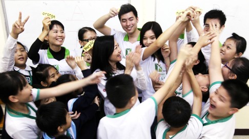 Hang Seng volunteers help students learn English in Shamshuipo Kaifong Welfare Association Primary School. Photo: Edward Wong