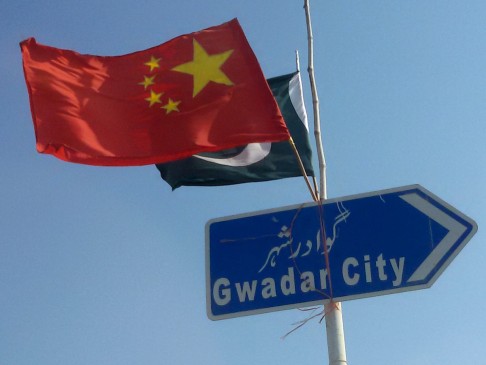 The two flags flutter from a signpost on the road to Gwadar.
