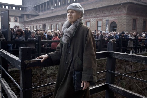 Renate Eco-Ramge, flanked by thousands of mourners, attends her husband's funeral at Sforza Castle, in Milan, last month.