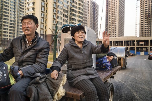 A couple, who were farmers until their land was taken by the government three years ago, return to where their village once stood, in Hebei province, last year. They will eventually receive an apartment in return for their land.