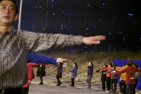 Former farmers participate in a group exercise class in a park built over their farmland on the outskirts of Beijing.