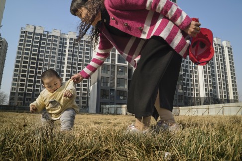 A former farmer plays with her granddaughter near a housing block just outside Beijing last year. The high-rises are home to farmers whose land was appropriated as part of China’s sweeping urbanisation drive.  DESKTOP USERS MAY CLICK TO LAUNCH PHOTO GALLERY