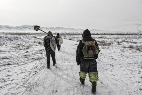 Ninjas on their way to work, outside Zaamar, one carrying on his back the green bowl that has earned them their nickname.