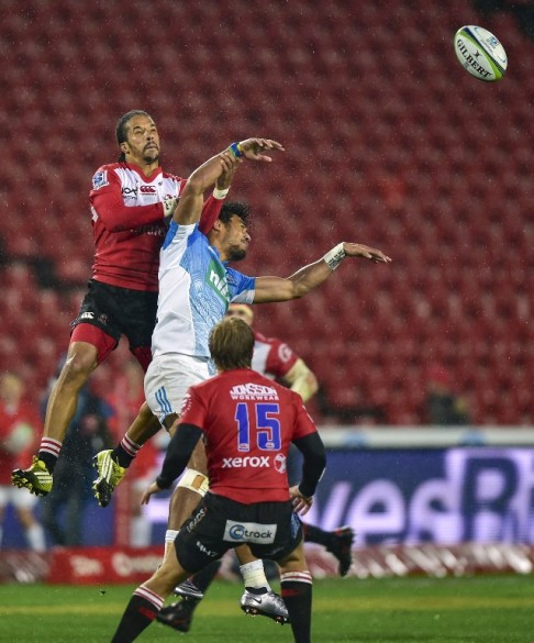 Courtnall Skosan of South Africa's Lions and Piers Francis of New Zealand's Blues jump for the ball during a Super Rugby match played recently in front of near-empty stands at Ellis Park in Johannesburg.
