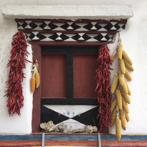 Corn and chillies hang from a window in Jiaju.