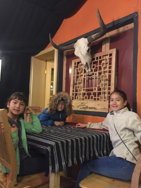 Maya, Eveline and Ilias await breakfast at the Hilam Hostel, in Kangding.