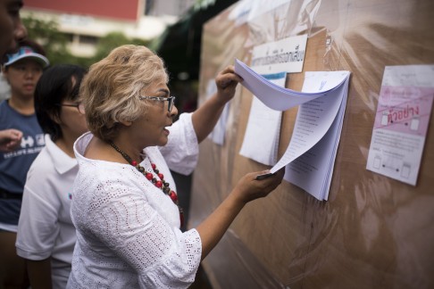 A Thai woman checks names at a polling station in Bangkok. Photo: AFP