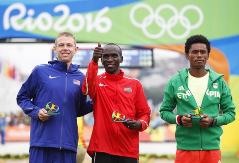 A podium thumbs-up from gold medal-winner Eliud Kipchoge flanked by runner-up Feyisa Lilesa (right) of Ethiopia and third-placed Galen Rupp of the USA. Photo:EPA