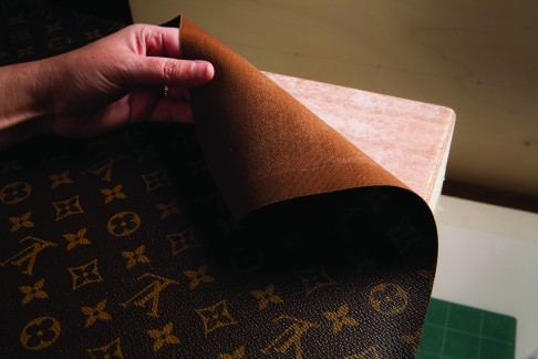 The craftsman covers the wood with either canvas or leather, but not before signing the trunk with a hidden stamp.