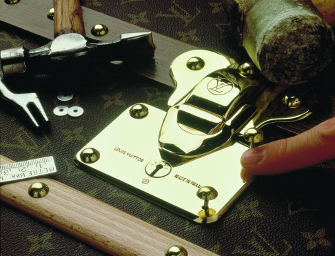 The craftsman fixes the seven-point lock onto the trunk by hand.