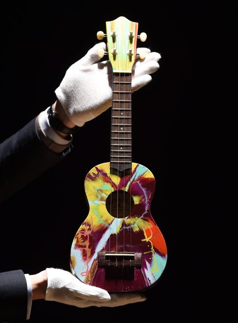 Look how small a ukulele is an adult’s hands. Photo: EPA