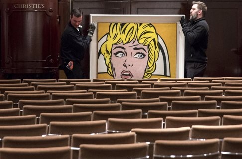 Workers wheel Roy Lichtenstein's "Nurse" through an emptied auction room after it sold for $95 million at auction in Manhattan. Photo: Reuters