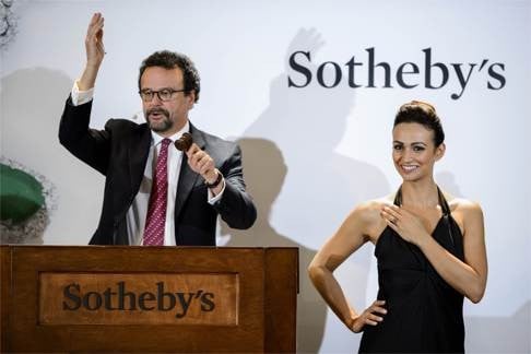 Sotheby’s auctioneer David Bennett brings down the gavel on the magnificent blue diamond, worn by a model, in Geneva on Wednesday. Photo: AFP