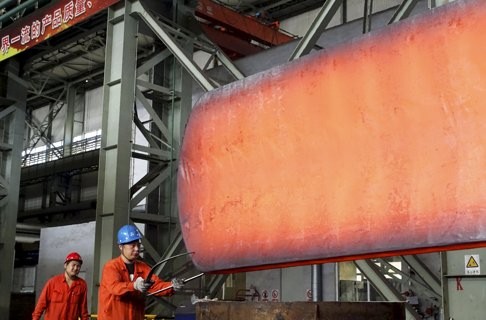 A worker measures a newly made steel block at a factory of in Dalian, Liaoning province. China has excess capacity – in steel, cement and so on – which can be applied to great use linking China to its neighbours. Photo: Reuters/China Daily