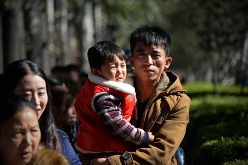 A man carries a child on a visit to Tiananmen Square in Beijing. Photo: AFP