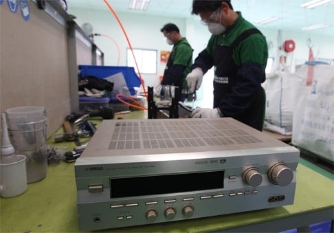 Workers at a recycling centre in the EcoPark in Tuen Mun check disposed of appliances in 2011. The HK$308 million EcoPark was trumpeted as a hi-tech hub but the industry remains at the lowest rung of the value-added ladder. Photo: May Tse